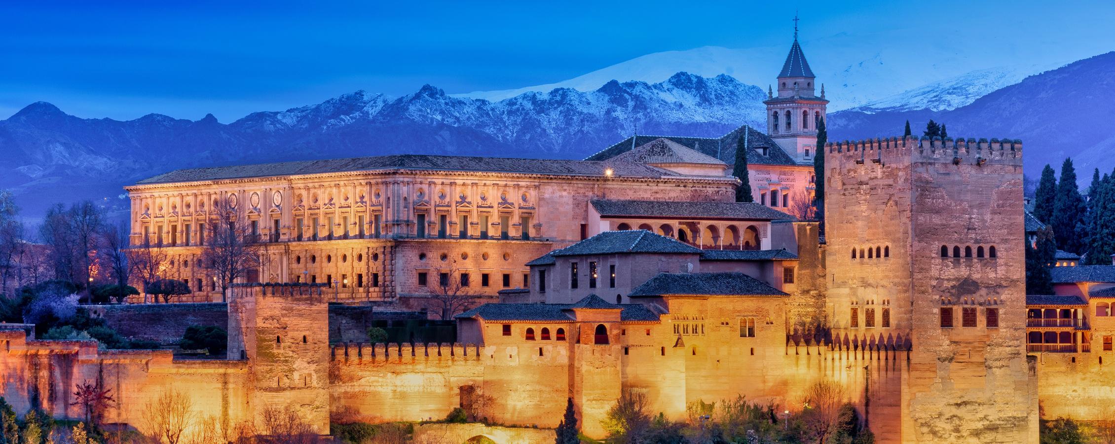 Castle Alhambra with mountains in the background.