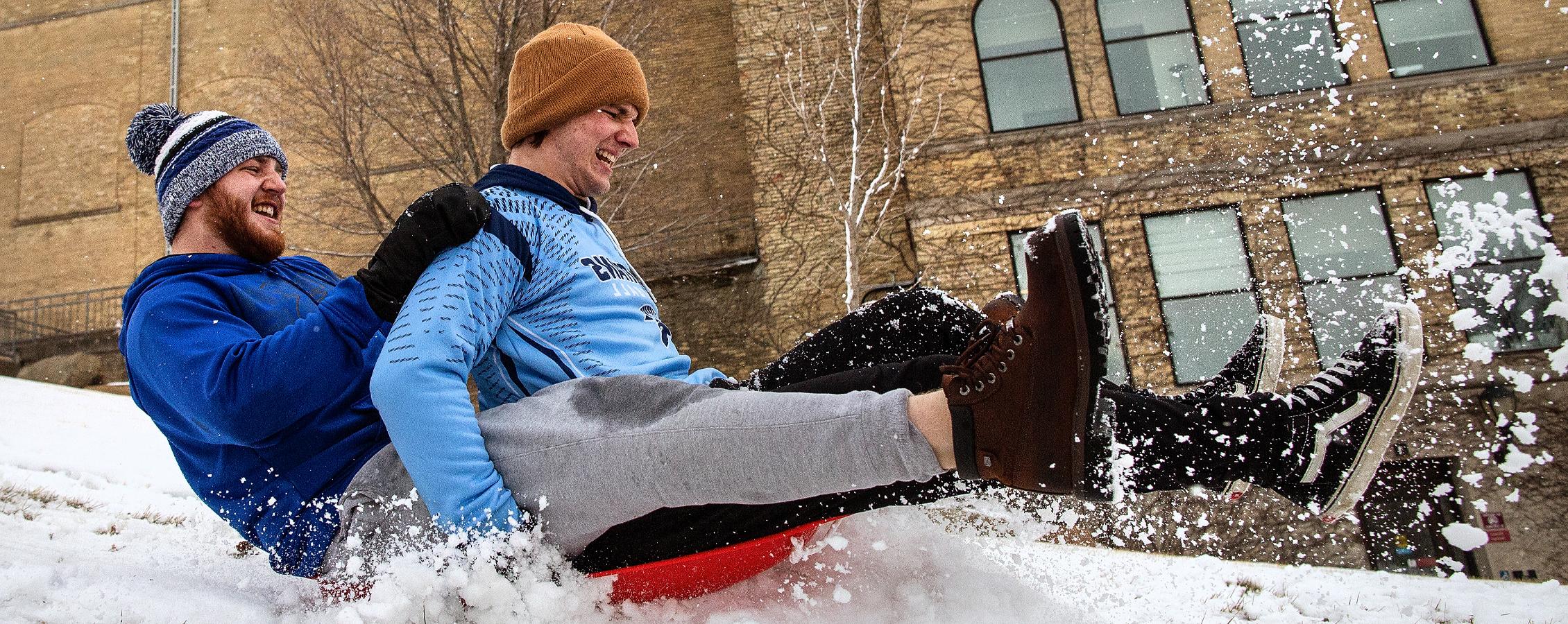 Two students sled down the hill next to Hyer Hall.